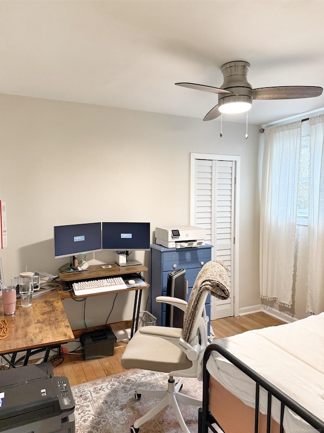 home office with light wood-style floors, baseboards, and a ceiling fan