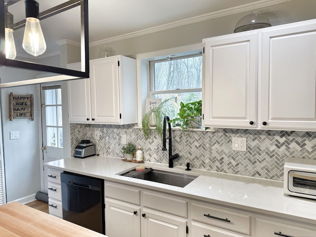 kitchen featuring decorative backsplash, light countertops, white cabinets, a sink, and dishwasher