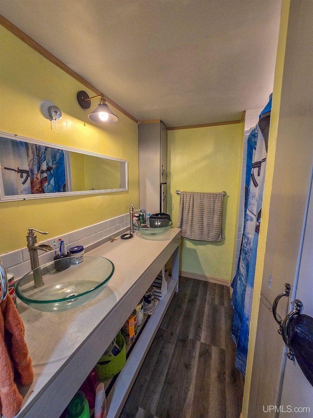 bathroom featuring double vanity, a sink, and wood finished floors