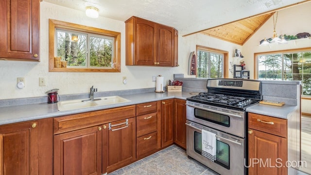 kitchen with brown cabinets, a sink, a peninsula, double oven range, and lofted ceiling