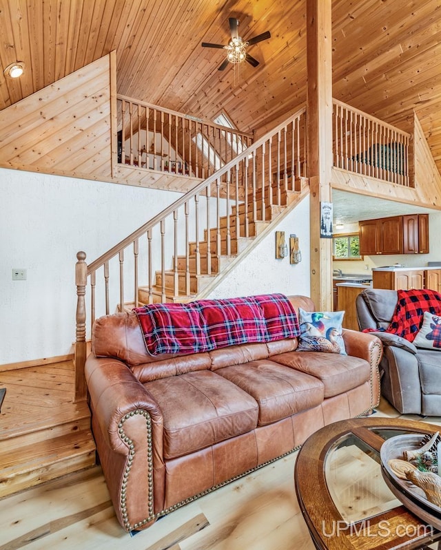 living room featuring wood ceiling, ceiling fan, and stairs