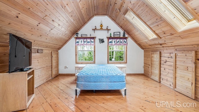 bedroom with light wood-style flooring, wooden walls, vaulted ceiling, and wooden ceiling