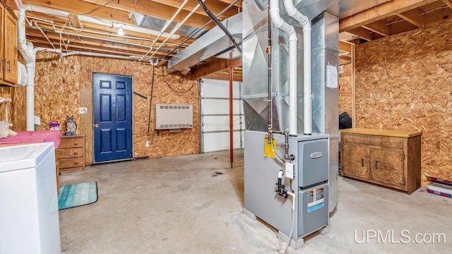 unfinished below grade area with heating unit and washer / dryer