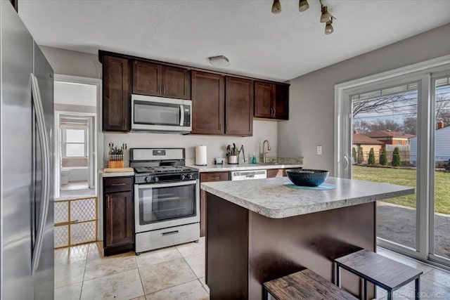 29094 Herbert St, Madison Heights, MI 48071 - kitchen with dark brown cabinetry, a breakfast bar area, appliances with stainless steel finishes, light countertops, and a sink