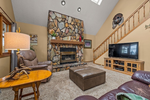carpeted living room featuring a fireplace, vaulted ceiling, stairs, and a textured ceiling