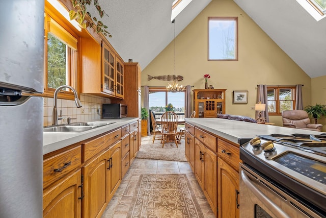 kitchen featuring a sink, high vaulted ceiling, a skylight, and stainless steel appliances