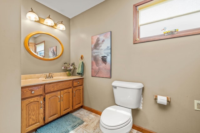 bathroom with vanity, baseboards, and toilet