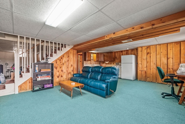 carpeted living area featuring wooden walls, visible vents, and stairs