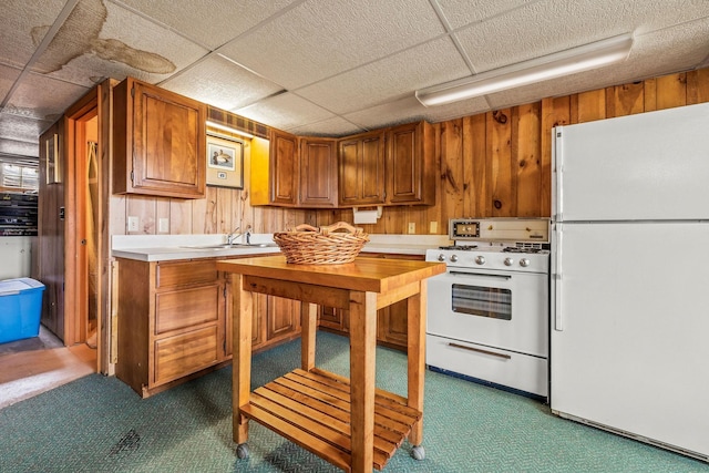 kitchen with light countertops, brown cabinetry, white appliances, and dark carpet