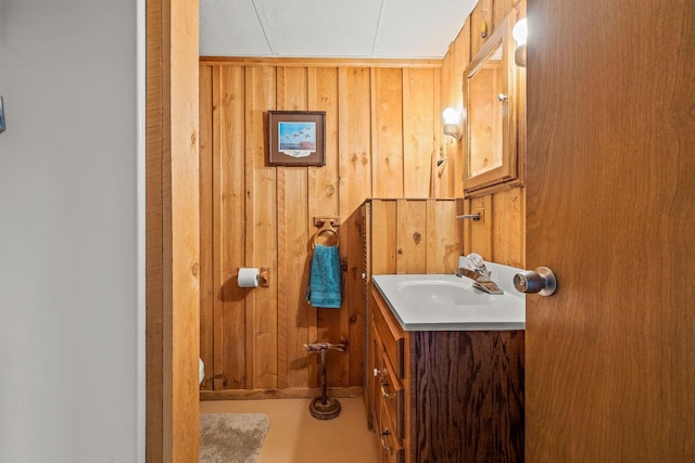 bathroom with wood walls and vanity