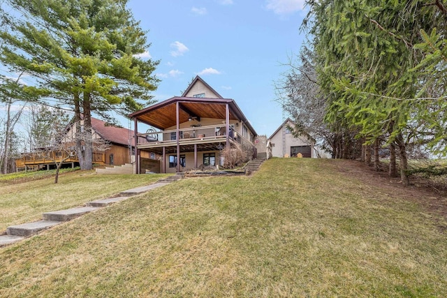 rear view of house featuring a yard, a deck, and stairs