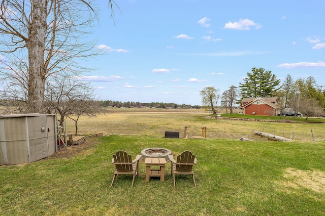 view of yard featuring a rural view and a fire pit