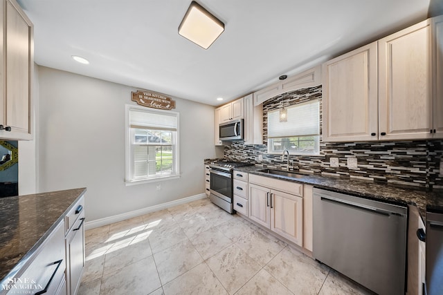 kitchen with baseboards, recessed lighting, tasteful backsplash, a sink, and appliances with stainless steel finishes