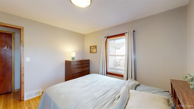 bedroom with baseboards, visible vents, and light wood-style flooring