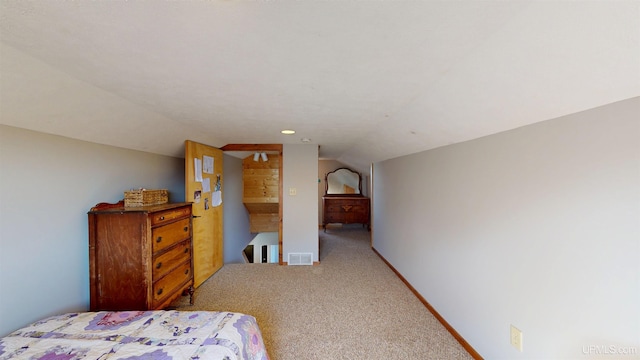 bedroom featuring visible vents, baseboards, carpet floors, and lofted ceiling