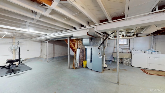 basement featuring heating unit, separate washer and dryer, and stairway