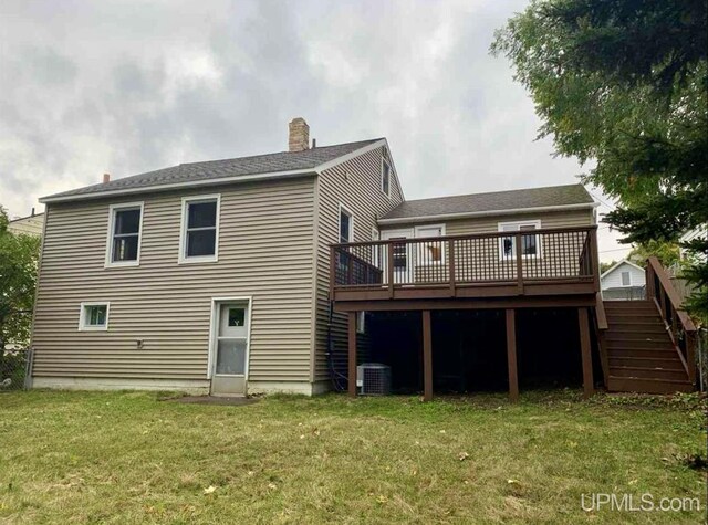back of property with a chimney, a deck, cooling unit, a yard, and stairs