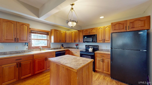 kitchen with a kitchen island, pendant lighting, a sink, light countertops, and black appliances