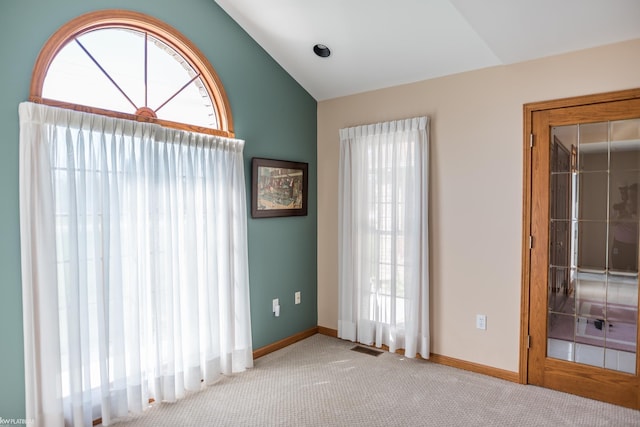 unfurnished room with baseboards, carpet, vaulted ceiling, and visible vents