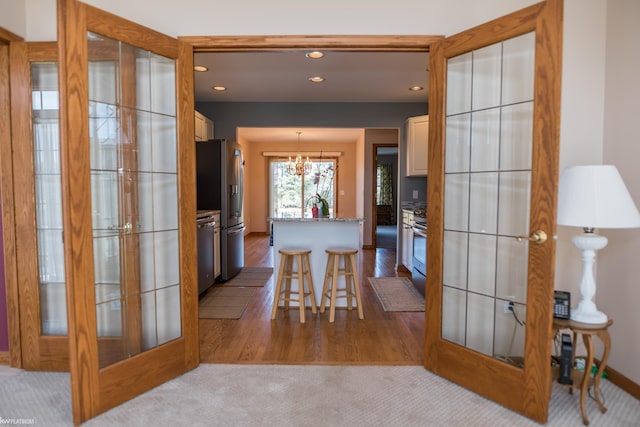 interior space featuring recessed lighting, an inviting chandelier, french doors, and wood finished floors