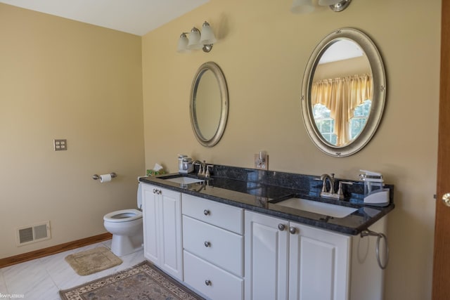 bathroom featuring visible vents, a sink, baseboards, and toilet