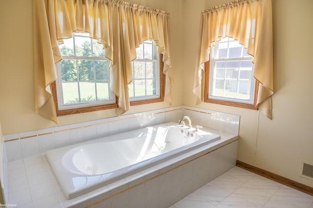 bathroom featuring baseboards, a bath, and visible vents