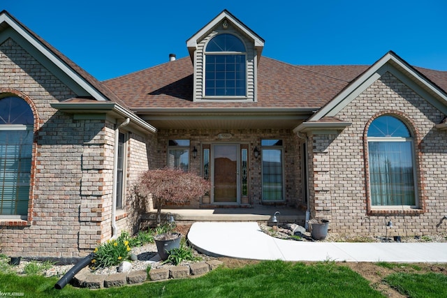 view of front of property featuring brick siding and a shingled roof