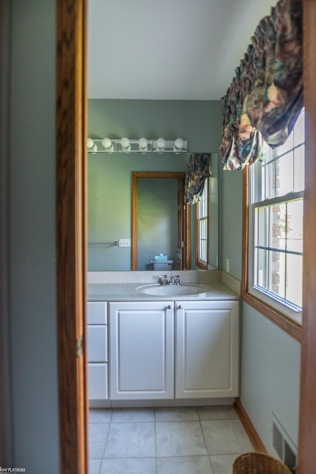 bathroom with tile patterned floors, visible vents, baseboards, and vanity
