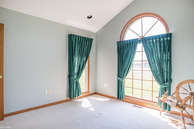 unfurnished room with baseboards, carpet, vaulted ceiling, and visible vents