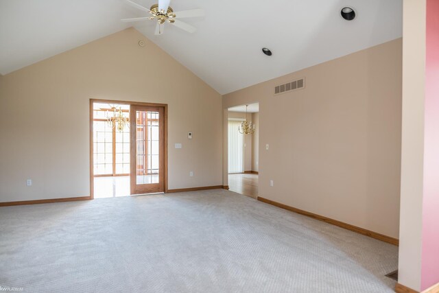 empty room featuring visible vents, baseboards, high vaulted ceiling, light colored carpet, and ceiling fan with notable chandelier