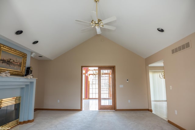unfurnished living room featuring visible vents, light carpet, a fireplace with flush hearth, ceiling fan with notable chandelier, and vaulted ceiling