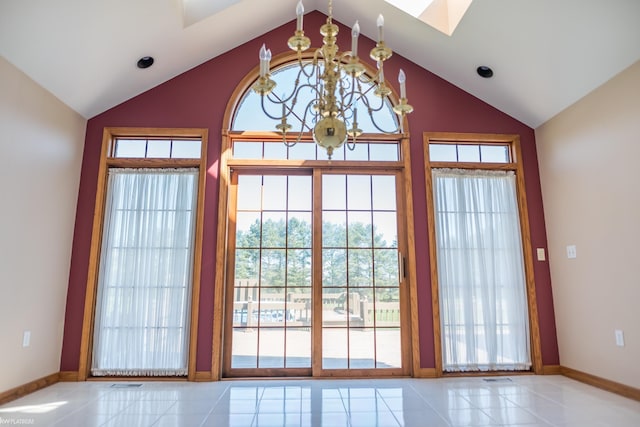 doorway to outside with vaulted ceiling with skylight, a chandelier, and a wealth of natural light