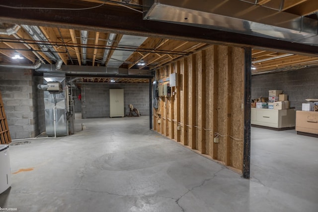 unfinished below grade area featuring concrete block wall and heating unit