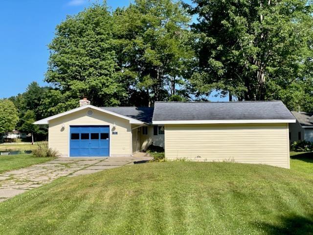single story home featuring a garage, a front lawn, and driveway