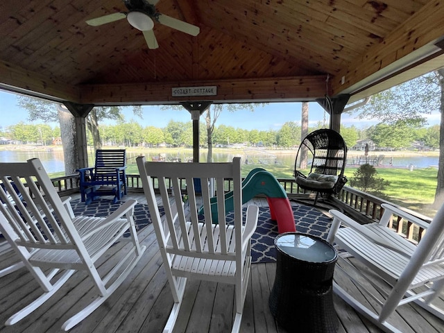 wooden terrace with a water view and ceiling fan