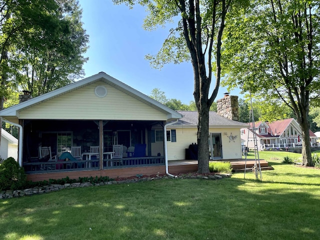 back of property with a lawn and a chimney