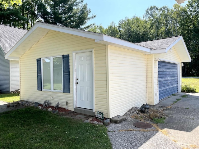 view of outdoor structure with a garage and aphalt driveway