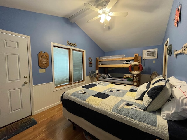 bedroom featuring ceiling fan, lofted ceiling with beams, a wall mounted air conditioner, a wainscoted wall, and wood finished floors