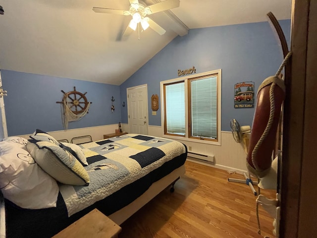 bedroom with lofted ceiling with beams, wainscoting, a ceiling fan, wood finished floors, and a baseboard heating unit