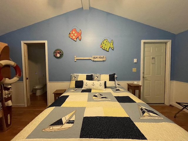 bedroom featuring vaulted ceiling, wood finished floors, and a wainscoted wall