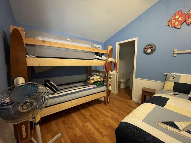 bedroom with lofted ceiling and wood finished floors