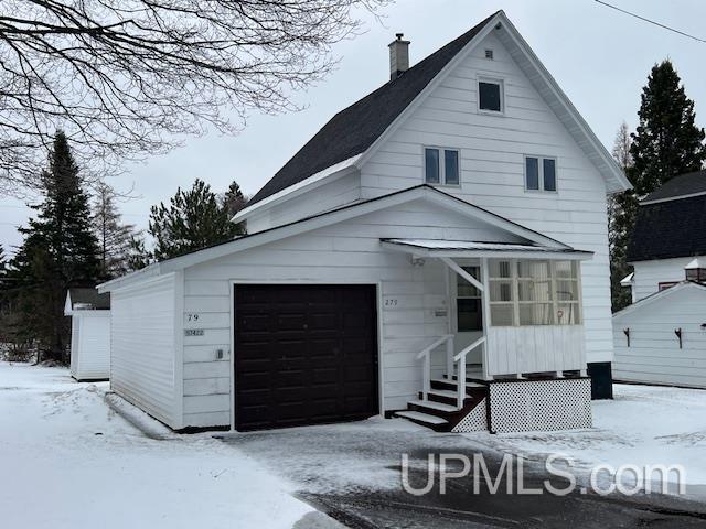 view of front of property with a garage, a chimney, and entry steps