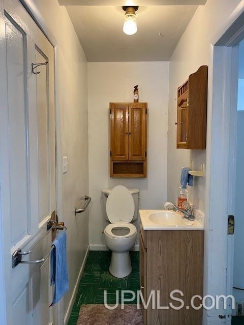 bathroom featuring vanity, baseboards, tile patterned flooring, and toilet