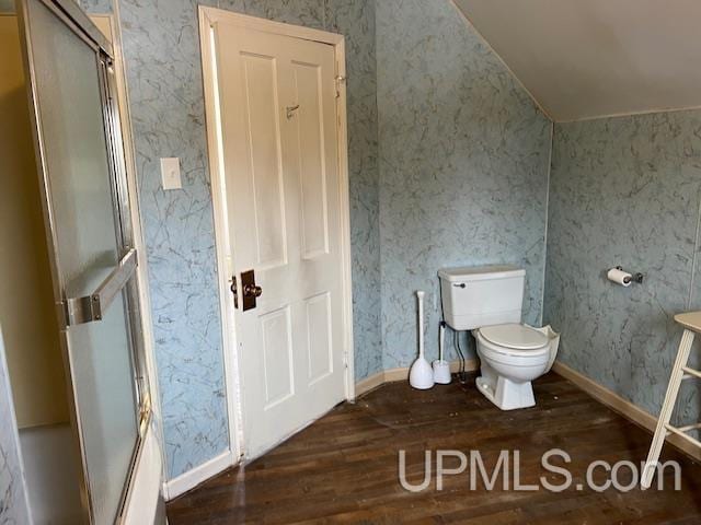 full bathroom with wallpapered walls, a shower with shower door, toilet, and hardwood / wood-style floors