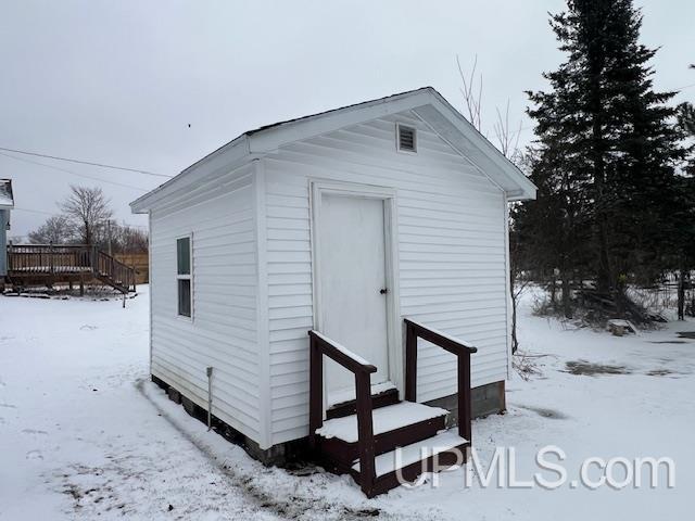 snow covered structure featuring an outdoor structure