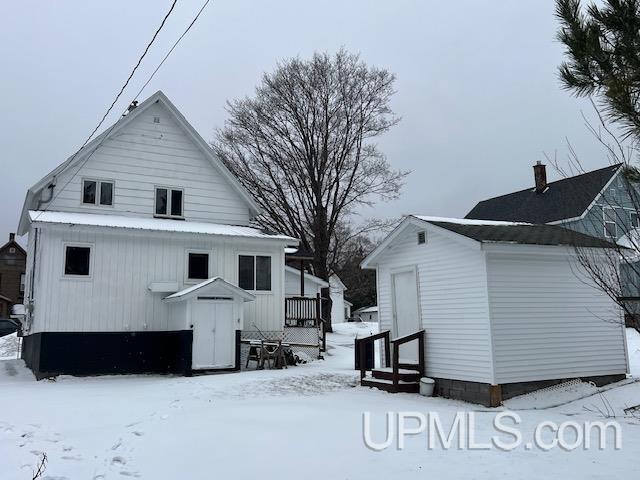 view of snow covered rear of property