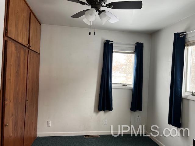 unfurnished bedroom featuring baseboards, carpet flooring, and visible vents