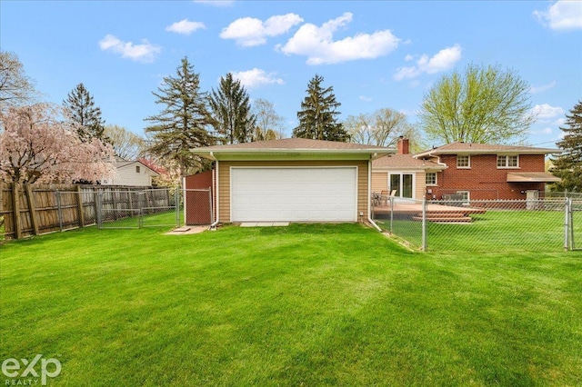 rear view of property with a yard, a fenced backyard, and a garage