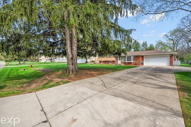 ranch-style house featuring a garage, driveway, a front lawn, and brick siding