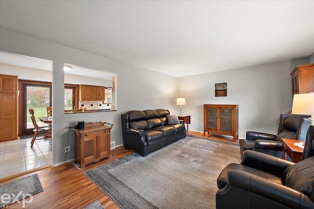 living room with baseboards, visible vents, and light wood-style flooring